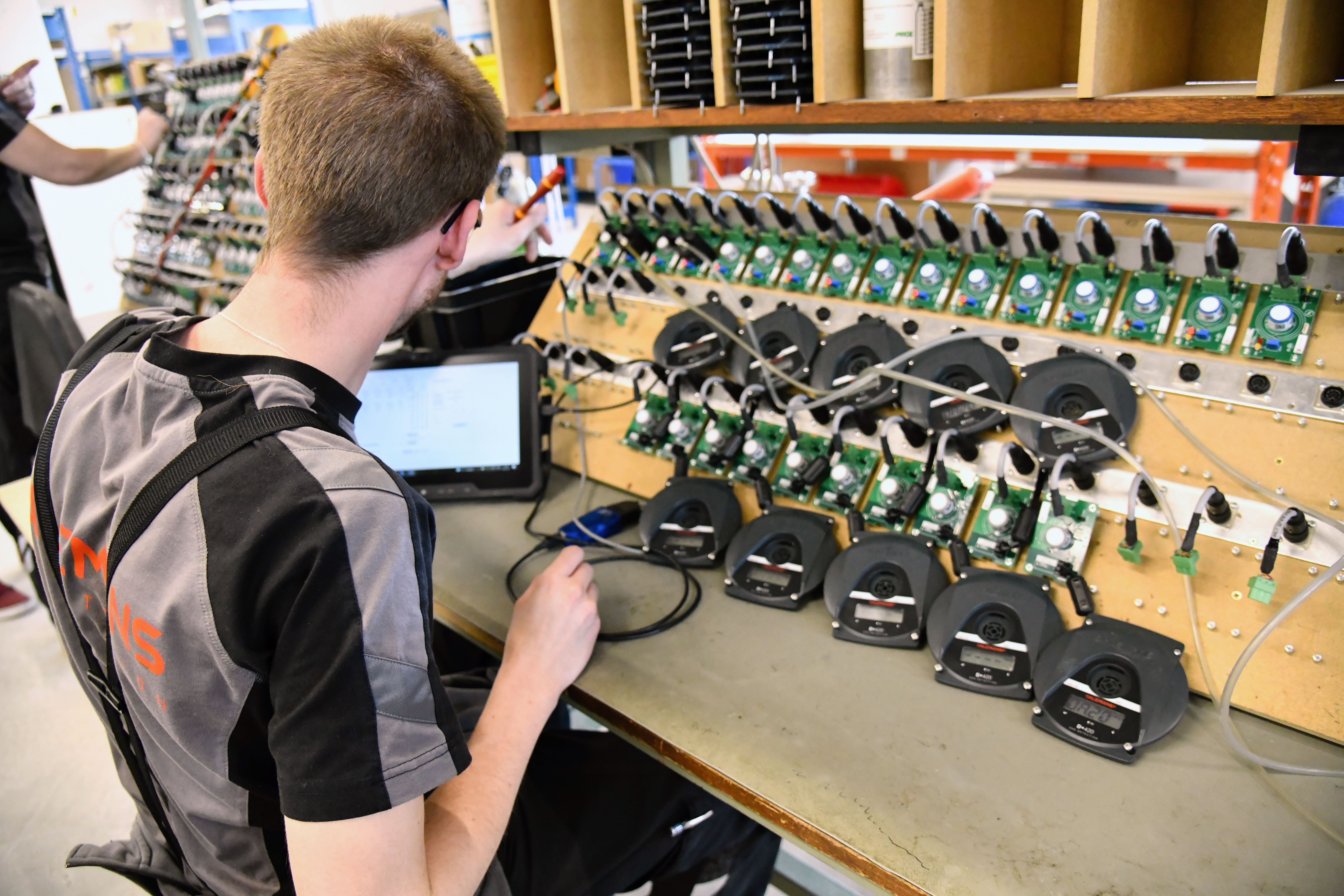 Technicien Dalemans en train de tester un détecteur de gaz sur une centrale de contrôle électronique